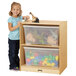 A girl standing next to a Jonti-Craft mobile wood toy storage cabinet filled with clear totes.