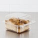 A Dart clear hinged plastic container with cake inside on a bakery counter.