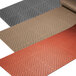 A group of brown, black, and white REVERS-a-MAT rubber runner mats.