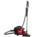 A Sanitaire canister vacuum cleaner with a red and black handle.