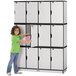 A young girl in a green shirt opening a Rainbow Accents black and gray laminate locker with triple stack sections.