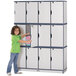 A young girl opening a Rainbow Accents navy triple stack locker with grey trim.