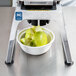 A machine coring green apples on a table.