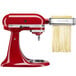 A KitchenAid pasta cutter attachment with red accents.