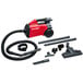 A red and black Sanitaire canister vacuum cleaner with hose and accessories.