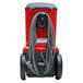 A red and black Sanitaire canister vacuum cleaner with a cord attached.