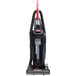 A Sanitaire bagless upright vacuum cleaner with a red handle.