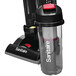 A Sanitaire bagless upright vacuum cleaner with a black container and red lid.