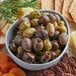 A bowl of olives and crackers.