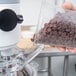 A person using a Globe countertop mixer to mix chocolate chips.