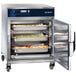 Alto-Shaam undercounter cook and hold oven with trays of food in it.