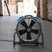 A black and blue XPOWER X-47ATR industrial fan on a pallet.