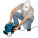 A man wearing a hat and holding a blue XPOWER air mover.