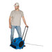 A man standing next to a blue XPOWER air blower with telescopic handle and wheels.