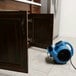A blue XPOWER air blower on the floor.