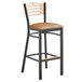 A Lancaster Table & Seating black bistro bar stool with a light brown wood seat and backrest.