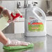 A hand in a glove using a SC Johnson spray bottle to clean a counter.