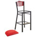 A Lancaster Table & Seating black metal bistro bar stool with mahogany wood back and a red vinyl seat.