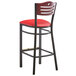 A Lancaster Table & Seating black bistro bar stool with red vinyl seat and mahogany wood back.