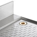 A Regency stainless steel underbar drainboard with a drain.