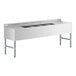 A white rectangular stainless steel Regency underbar sink with two drainboards and four bowls.