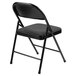 A National Public Seating black metal folding chair with black padded fabric seat.