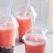 Three plastic cups of pink drinks with Choice multicolor striped straws.