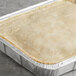 A Spring Glen Fresh Foods 7.25 lb. tray of baked chicken pie on a table.