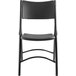 A National Public Seating black metal folding chair with black plastic seat and back.