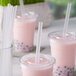 Three pink drinks with Choice translucent pointed straws.