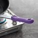 A purple silicone handle sleeve on a frying pan.