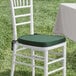 A white chair with a Lancaster Table & Seating hunter green cushion on it.