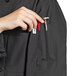 A person wearing a black Uncommon Chef long sleeve chef coat with 10 buttons and a tool in their pocket.