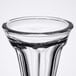 A close up of a clear Libbey sundae glass with a black rim.