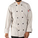 A man wearing a white Uncommon Chef long sleeve chef coat with 10 buttons smiles.