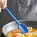 A person cooking shrimp in a pan with a blue Mercer Culinary Hell's Tools high temperature spoon.