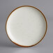 An Acopa Keystone stoneware coupe plate in white with brown specks.