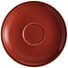 An Acopa Sedona Orange stoneware saucer with a speckled rim and a circle in the center.