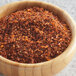 A bowl of red and orange McCormick Grill Mates Mesquite seasoning on a table.