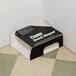 A black and white Terro box with white text on a tile floor.