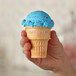 A hand holding a Keebler Eat-It-All cake cone with blue and pink sprinkles.