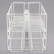 A white wire rack with several rows of compartments for dinner plates.