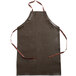 A brown San Jamar vinyl apron with brown straps.