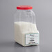 A clear plastic container of Regal Spanish Natural Flower of Salt with white powder inside.