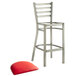 A Lancaster Table & Seating metal bar stool with red vinyl padded seat.