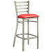 A Lancaster Table & Seating clear coat finish metal ladder back bar stool with a red vinyl padded seat.