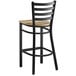 A Lancaster Table & Seating black ladder back bar stool with a driftwood seat.