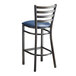 A Lancaster Table & Seating distressed copper finish metal ladder back bar stool with a navy blue vinyl padded seat.