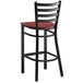 A black Lancaster Table & Seating ladder back bar stool with a mahogany seat.
