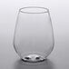A Choice clear plastic stemless wine sampler glass with a small amount of liquid inside.